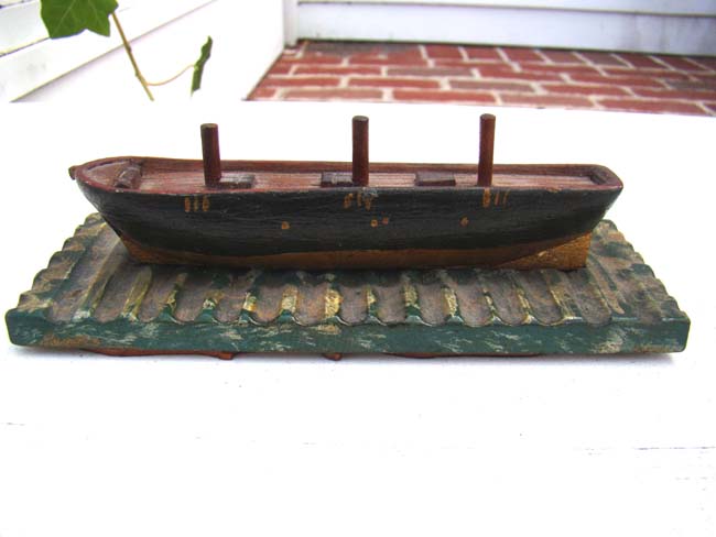 A charming miniature 19th century carved wooden sailing ship at drydock, the underside of base with five whaling log book stamps.